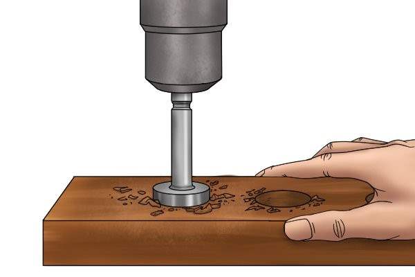 Forstner drill bit drilling a hole into a piece of wood for the magnet